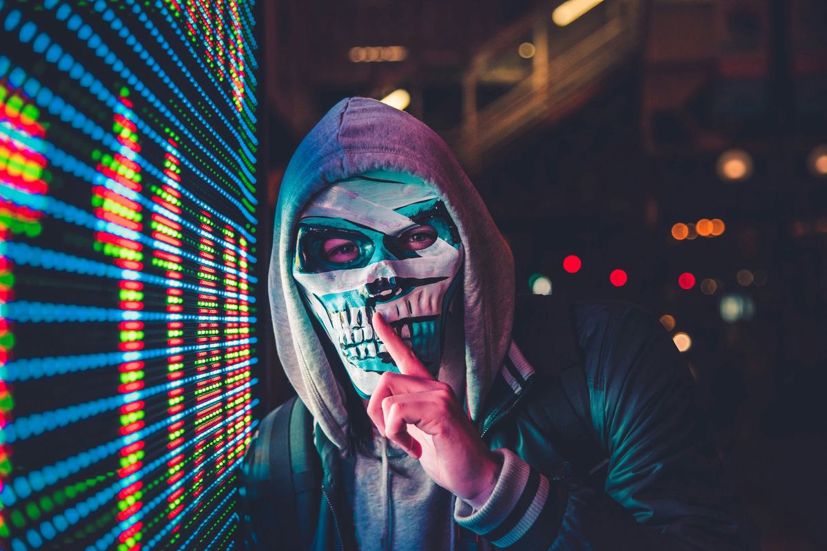 Masked hacker next to LED display